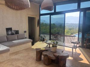 uma sala de estar com um sofá, uma mesa e janelas em Silvaate stay em Dhamni mais 24 fotografias