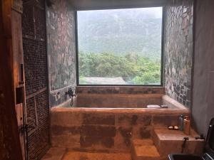 uma casa de banho com uma grande janela e uma banheira em Silvaate stay em Dhamni