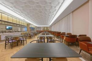 Da QaidamにあるVienna Hotel Qinghai Dachaidanのレストラン内のテーブルと椅子のあるダイニングルーム