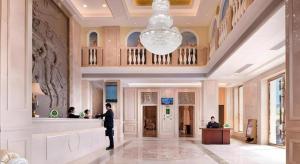 a man standing in the lobby of a building at Vienna Hotel Guangdong Shaoguan Ruyuan Yao Cultural Square in Fucheng