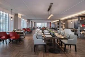 a restaurant with wooden tables and white chairs at Echeng Hotel Nanning the Mixc Convention in Nanning