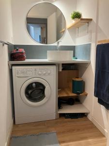 une machine à laver dans une salle de bain avec un miroir dans l'établissement grand appartement Sete, à Sète