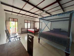 une chambre avec un lit et une table dans une pièce dans l'établissement Vidara Guest House, à Weligama
