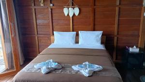 Casablanca Bira Resort في Tabutule: غرفة نوم بها سرير مع مناشف عليه