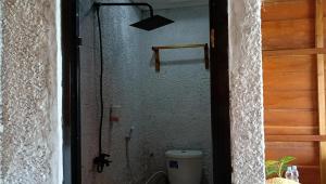 Casablanca Bira Resort في Tabutule: باب حمام مع مرحاض في غرفة