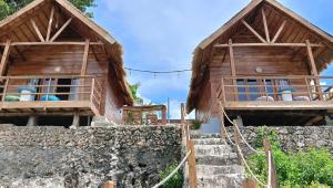 Casablanca Bira Resort في Tabutule: مبنيان خشبيان بجدار حجري وسلالم +36 صورة