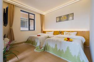 una camera d'albergo con due letti e una finestra di Shangri-La Chenxia Courtyard Homestay a Shangri-La