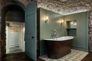 a bathroom with a large tub in a room at Old Town Chambers, Autograph Collection in Edinburgh +92 photos
