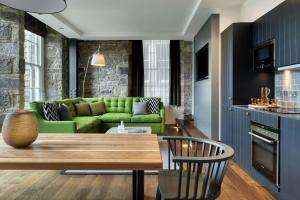 a living room with a green couch and a table at Old Town Chambers, Autograph Collection in Edinburgh