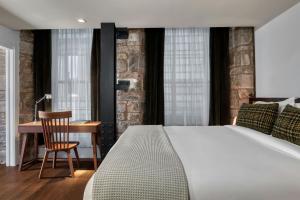 a bedroom with a bed and a desk and a chair at Old Town Chambers, Autograph Collection in Edinburgh