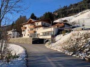 a building on a hill with snow on the ground at Apartment with Alpine views in Fügenberg
