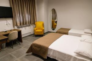 een hotelkamer met twee bedden, een bureau en een stoel bij La Corte Park Hotel & Spa in Palma Campania +23 foto's