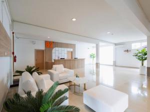 a living room with white furniture and a table at B2 Phayao Boutique & Budget Hotel in Ban Rong Ha