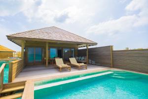 a villa with a deck and a swimming pool at Nala Maldives by Jawakara in Lhaviyani Atoll