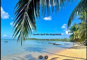 a beach with palm trees and boats in the water at Deep Dream Chalet in Hinkong