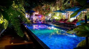 Viluveli Holiday Retreat في Hanimaadhoo: مسبح في ساحة فيها كراسي ومظلات