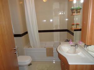 une salle de bain avec un lavabo, une baignoire et des toilettes dans l'établissement Apartamento Praia São Martinho do Porto, à São Martinho do Porto 27 autres photos
