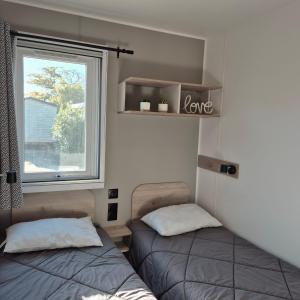 Ένα ή περισσότερα κρεβάτια σε δωμάτιο στο L'Eden Mobil Home à 200m de la plage Camping 5 étoiles Parc Aquatique