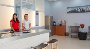 two women standing behind a counter in a kitchen at Soontree House Hotel in Udon Thani