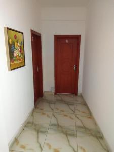 an empty room with two doors and a tile floor at Mon soleil in Luanda