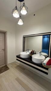 a bathroom with two sinks and a large mirror at Nizwa heart in Nizwa +8 photos