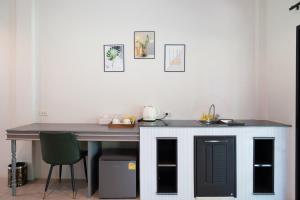 a kitchen with a counter and a table and a sink at Trat Tara Boutique Hotel in Ban Sa Sisiat