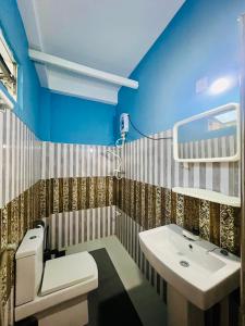 ein Badezimmer mit weißer Toilette und Waschbecken in der Unterkunft Opera Tangalle in Tangalle