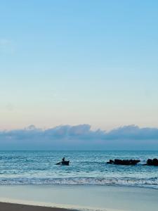Eine Person befindet sich im Meer auf einem Surfbrett. in der Unterkunft Opera Tangalle in Tangalle