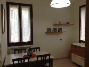 a kitchen with a table and chairs and windows at Appartamento Paleocapa in Marghera