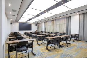 a room with tables and chairs and a projection screen at GreenTree Eastern Hotel Tianjin Dongli Development Zone Xinli Metro Station in Tianjin
