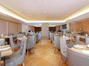 Vienna Hotel Chengdu Xinjin Old Pier Liujianian Metro Station في Xinjin: مطعم مع طاولات وكراسي ومطبخ