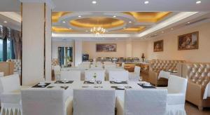 a large dining room with white tables and white chairs at Vienna Hotel Chongqing Yongchuan High-Speed Railway Station Xinglong Lake in Yongchuan