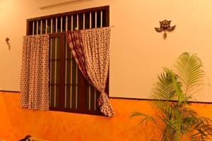 Un edificio con una ventana y una planta delante. en Lakshya - The Nature's Farm, en Karungulam