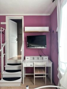 a room with a tv on a purple wall at hotel Bologna in Fanano