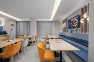 a restaurant with tables and chairs in a room at Jinjiang Inn Zhuhai Xiangzhou Qinglv Middle Road Theater in Zhuhai