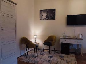 a living room with two chairs and a fireplace at Bed and Chic art rooms in Trieste