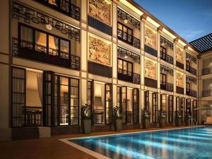 an external view of a building with a swimming pool at Vinh Hung 2 City Hotel in Hoi An