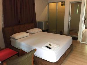 um quarto com uma cama e uma cadeira vermelha em 189 Resort em Ban Khlong Samrong