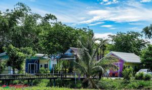 a row of colorful houses with a palm tree at BanRai ChernMa Resort in Tak