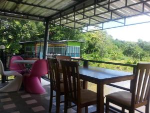 a table and chairs on a patio with a view at BanRai ChernMa Resort in Tak