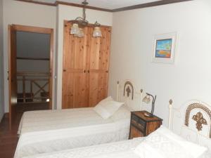 1 dormitorio con 2 camas y puerta de madera en Casa Ilhéu - Fajã do Fisher en Feteira