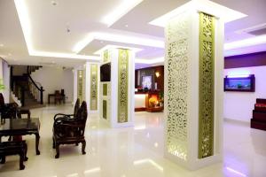 a living room with columns and a table and chairs at Rain Bow Hotel in Ho Chi Minh City
