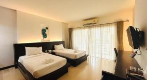 a hotel room with two beds and a window at The O Valley Hotel in Ban Tha Phala Nua