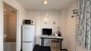 a small room with a desk with a computer on it at 難波南52 in Osaka