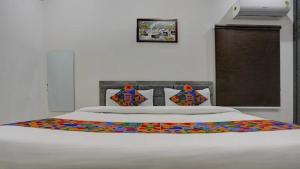 Una cama blanca con una manta de colores. en Kashi Home Stay, en Jāmb