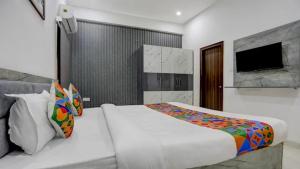 Un dormitorio con una cama y un televisor. en Kashi Home Stay, en Jāmb