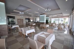 アランヤにあるAura Residenceの白いテーブルと椅子が備わるレストランのダイニングルーム