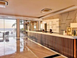 duas pessoas sentadas em um bar com a praia ao fundo em Awesome Hotel em San Juan