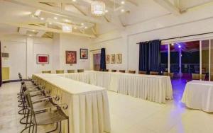 Una gran sala con mesas y sillas. en Vitalis White Sands, en Baraoas 147 fotos más