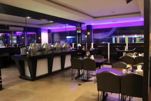 un restaurante con mesas, sillas e iluminación púrpura en Balai View Hotel, en Tanjung Balai Karimun